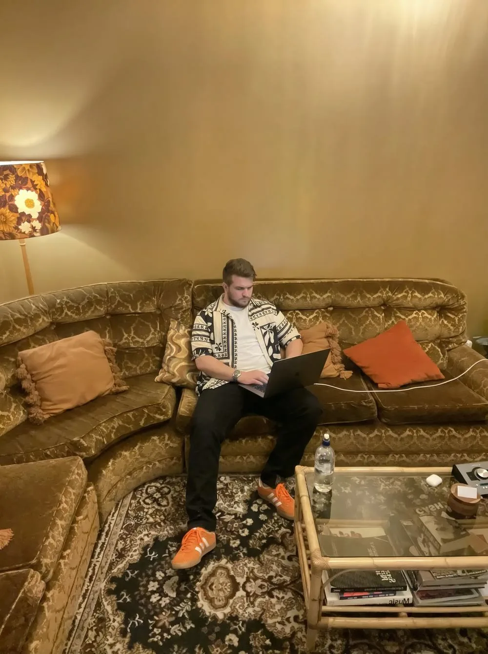 Ben on a couch with a laptop, writing