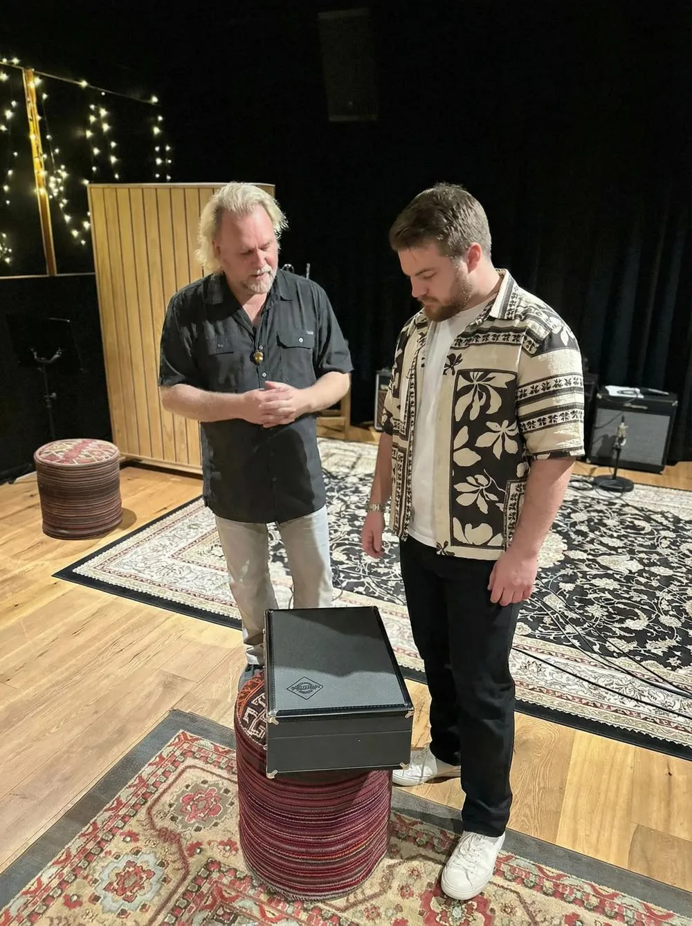 Ben and an engineer talking over a piece of gear in the studio